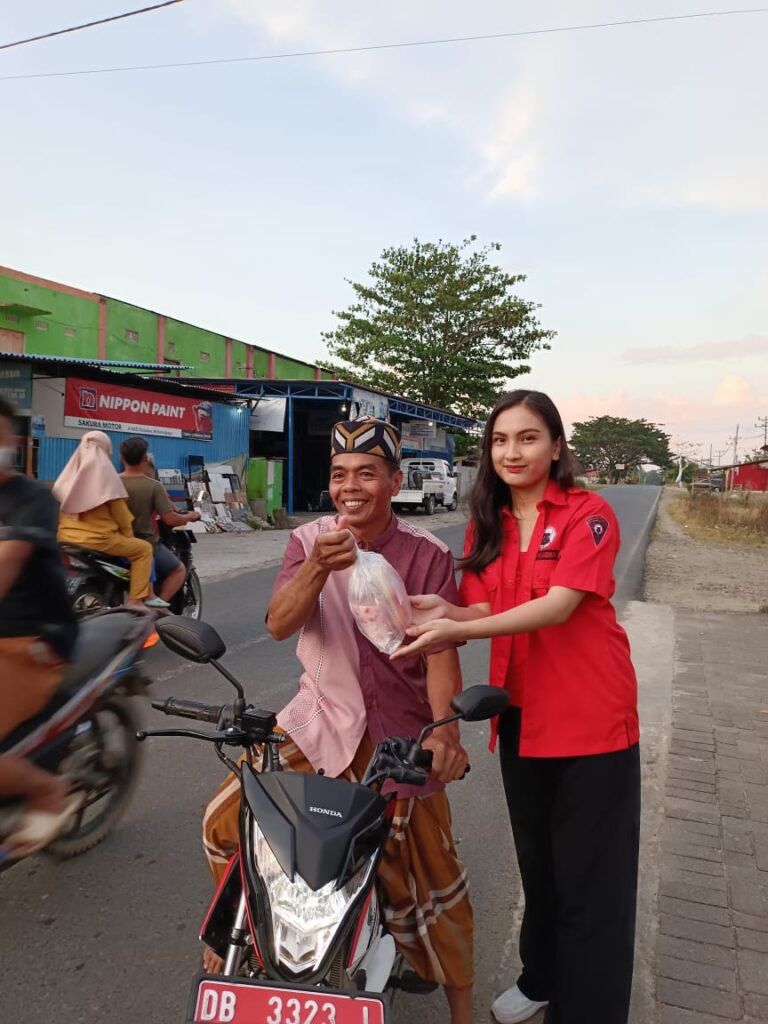 Ketua DPC BMI Kabupaten Bolmong, Qhesia Qren Tuuk saat berbagi takjil di Jalan Trans Sulawesi, Desa Doloduo Induk
